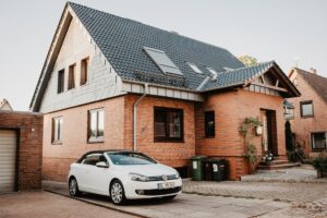 Symbolbild Einfamilienhaus mit Klinker und Anbau sowie Garage - den Immobilienwert ermitteln lassen hilft bei vielen Kaufentscheidungen