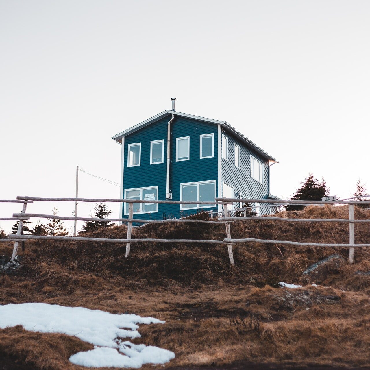 Zu sehen ist ein eher nordisches Haus im Stil einer Stadtvilla, aber in freiem, hügeligen Gelände gelegen. Oft sind es diese speziellen Immobilien, für die ein Wert ermittelt werden muss. Dafür wird ein Immobiliengutachten nach § 194 BauGB angefertigt.